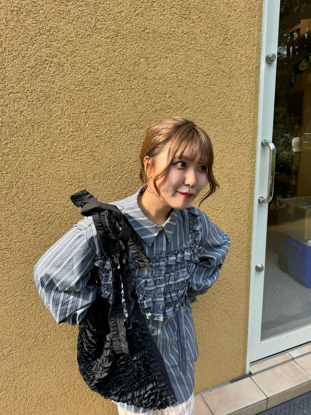 ブルー系のシャツ/ブラウス、ホワイト系のパンツ、ブラック系のトートバッグを着用したレディースの夏コーディネートの3枚目の写真