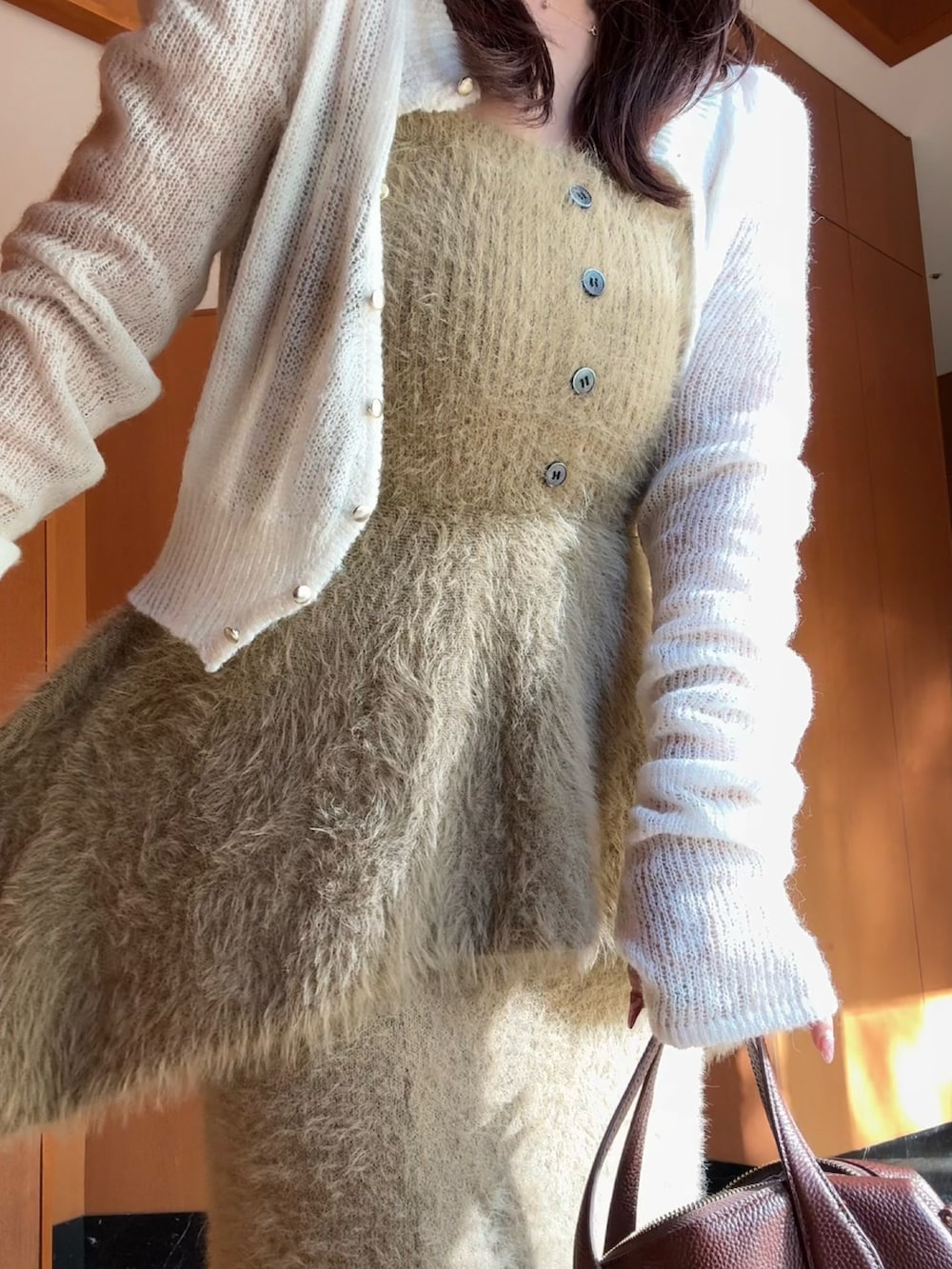 ブラウン系のボストンバッグ、ベージュ系のサンダル、ベージュ系のトップスを着用したレディースの秋コーディネートの3枚目の写真