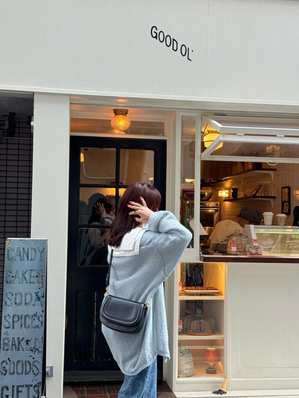 シルバー系のパンプス、ブルー系のカーディガン/ボレロ、ブラック系のショルダーバッグを着用したレディースの春コーディネートの5枚目の写真