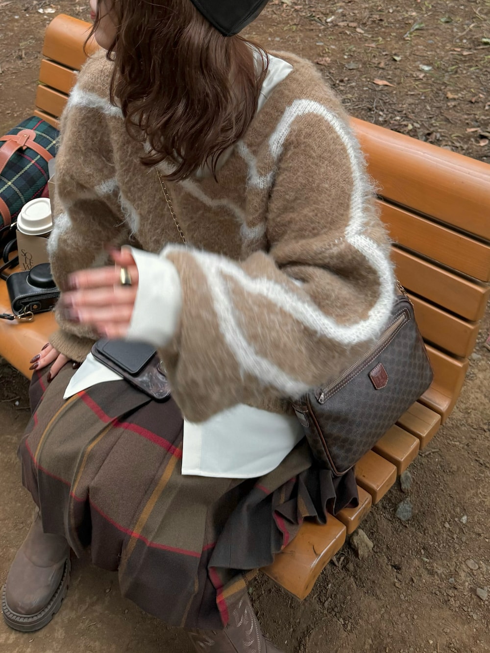 ブラウン系のニット/セーター、ブラウン系のスカート、ベージュ系のシャツ/ブラウスを着用したレディースの秋コーディネートの5枚目の写真