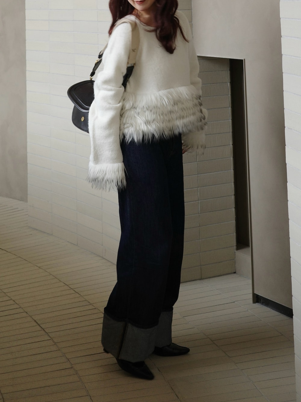 ブルー系のデニムパンツ、ホワイト系のニット/セーターを着用したレディースの冬コーディネートの4枚目の写真