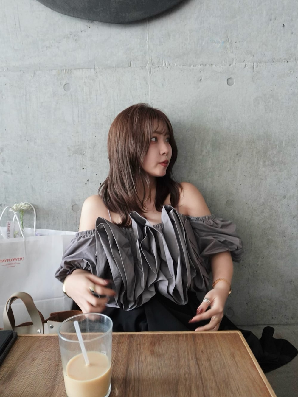 ベージュ系のハンドバッグ、グレー系のシャツ/ブラウス、ブラック系のパンツを着用したレディースの春コーディネートの4枚目の写真