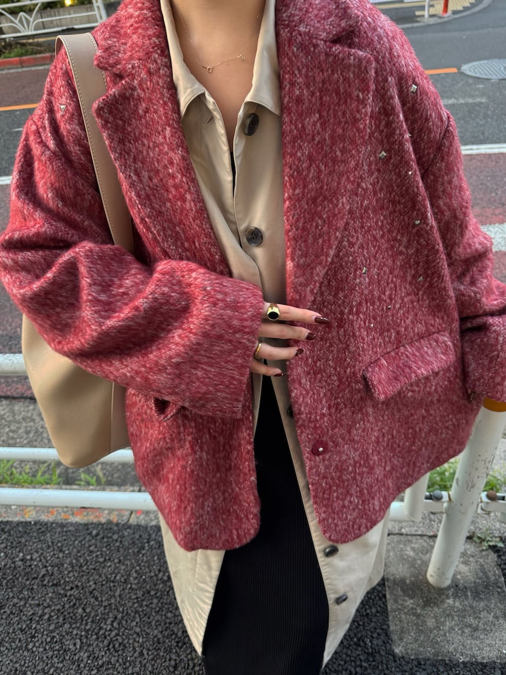 ベージュ系のステンカラーコート、ブラック系のブーツ、ベージュ系のショルダーバッグを着用したレディースの秋コーディネートの2枚目の写真