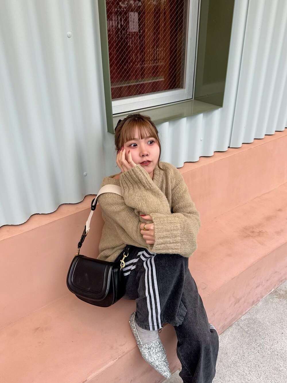 ベージュ系のニット/セーター、ブラック系のデニムパンツ、シルバー系のローファーを着用したレディースの春コーディネートの4枚目の写真