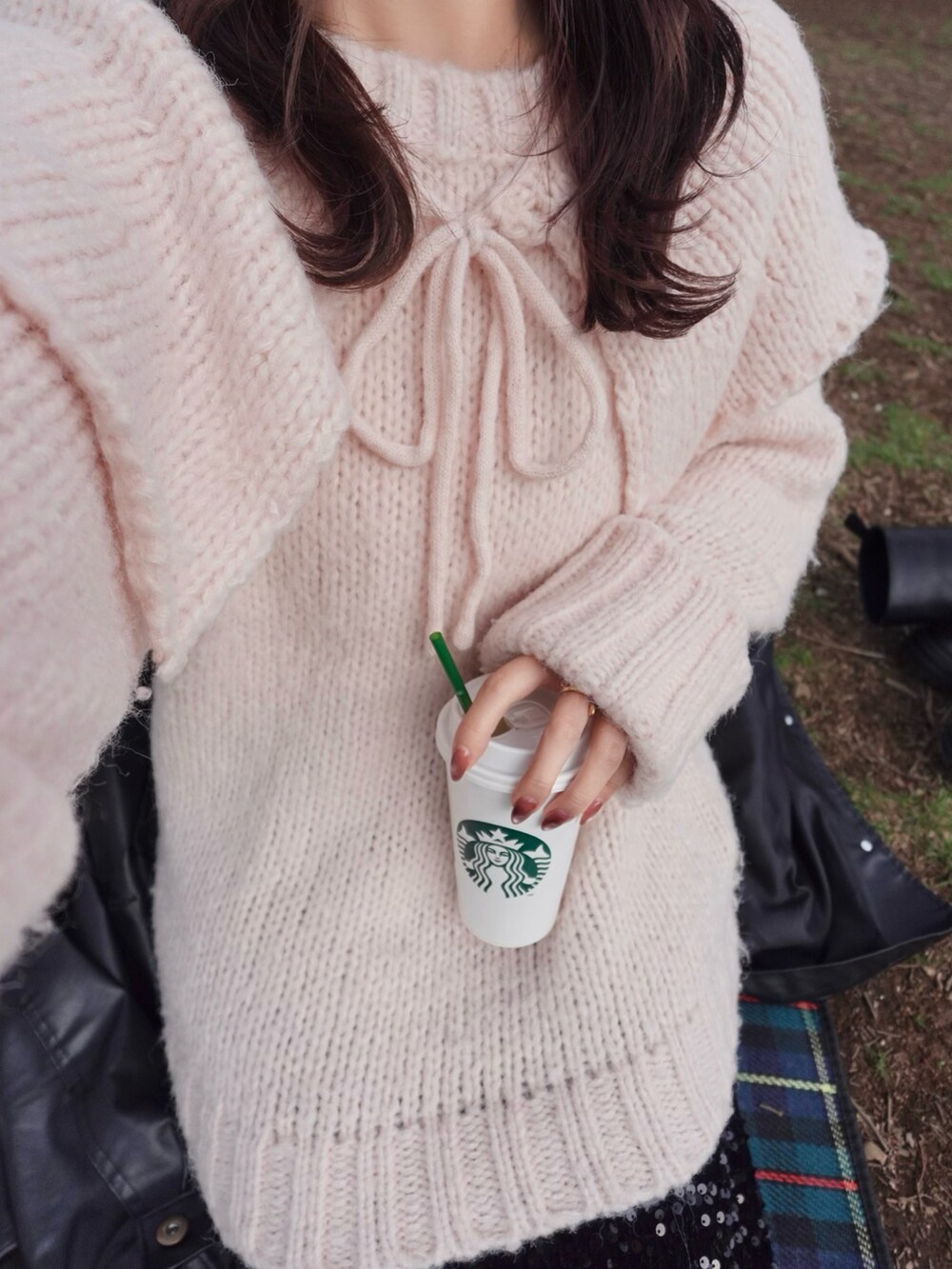 ブラック系のスカート、シルバー系のパンプス、ピンク系のパーカーを着用したレディースの春コーディネートの4枚目の写真