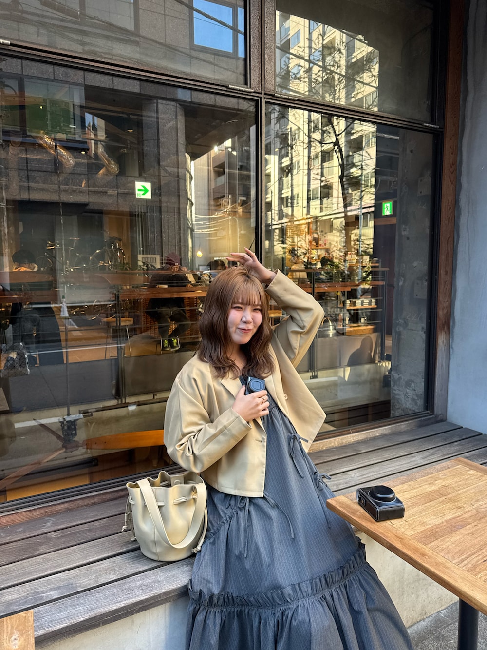 ベージュ系のテーラードジャケット、ブラック系のワンピース、ベージュ系のショルダーバッグを着用したレディースの春コーディネートの3枚目の写真