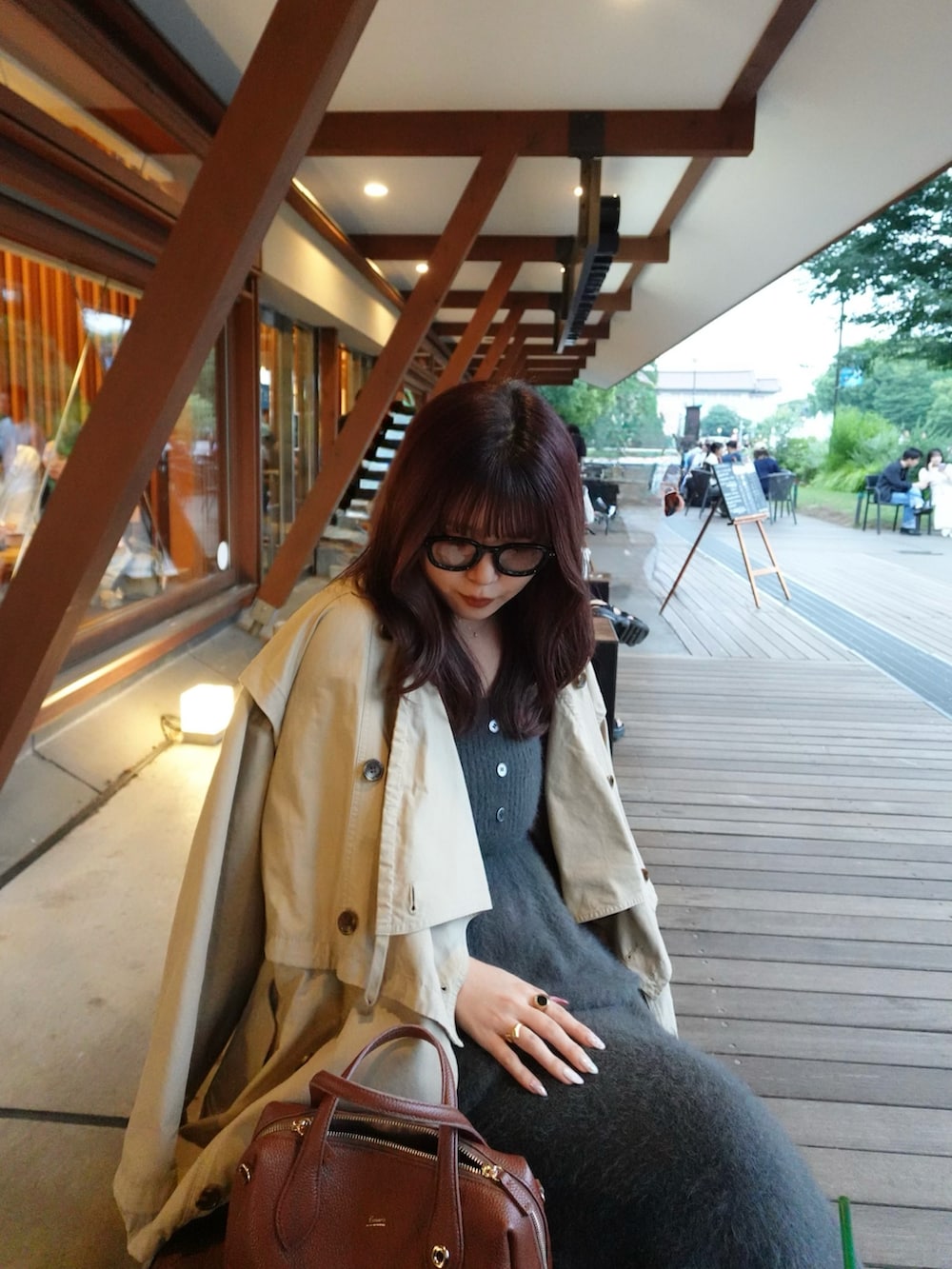 ブラック系のパンプス、グレー系のスカート、ブラウン系のボストンバッグを着用したレディースの秋コーディネートの2枚目の写真