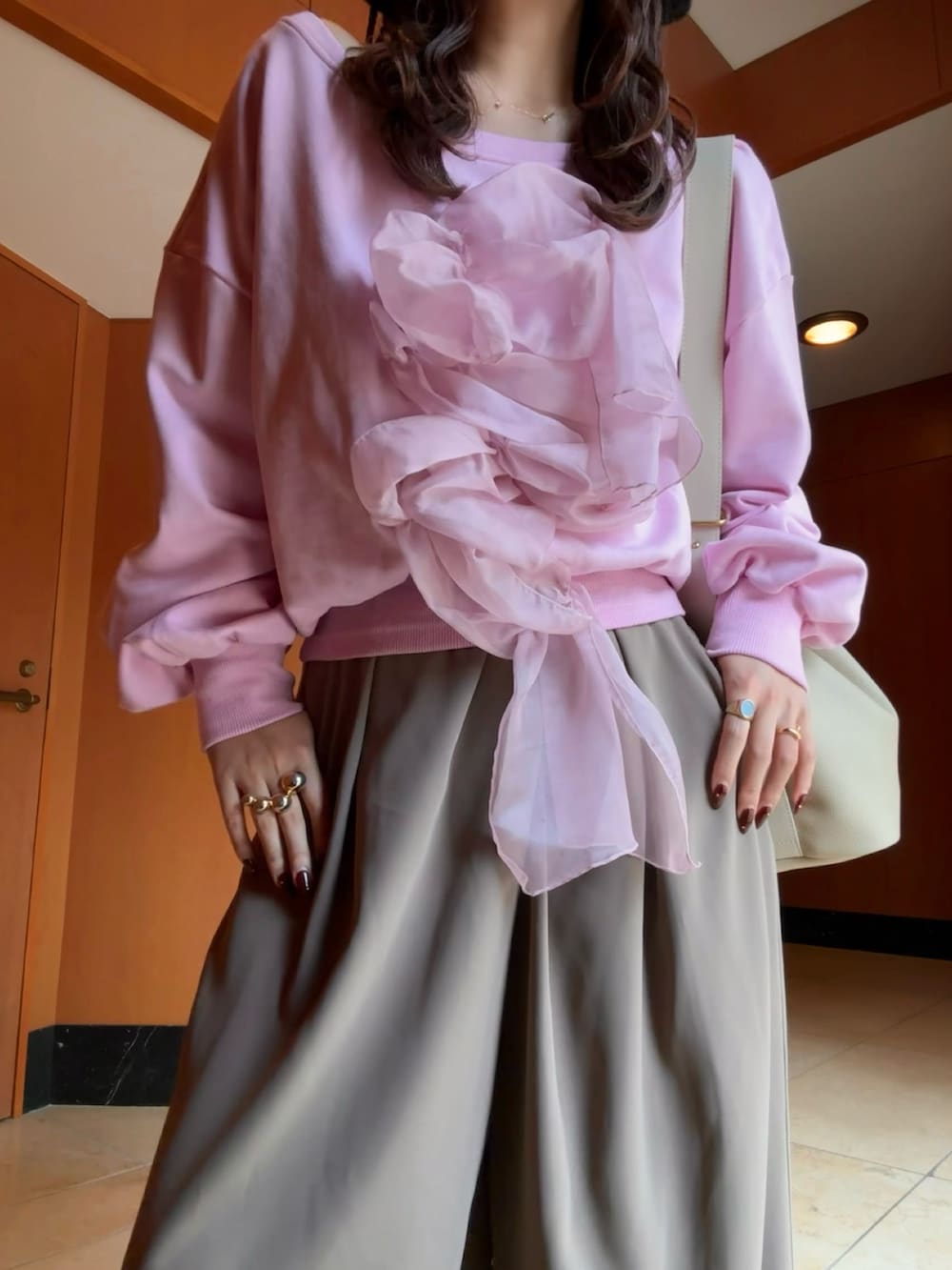 ブラック系のパンプス、ベージュ系のショルダーバッグ、ブラウン系のパンツを着用したレディースの秋コーディネートの2枚目の写真