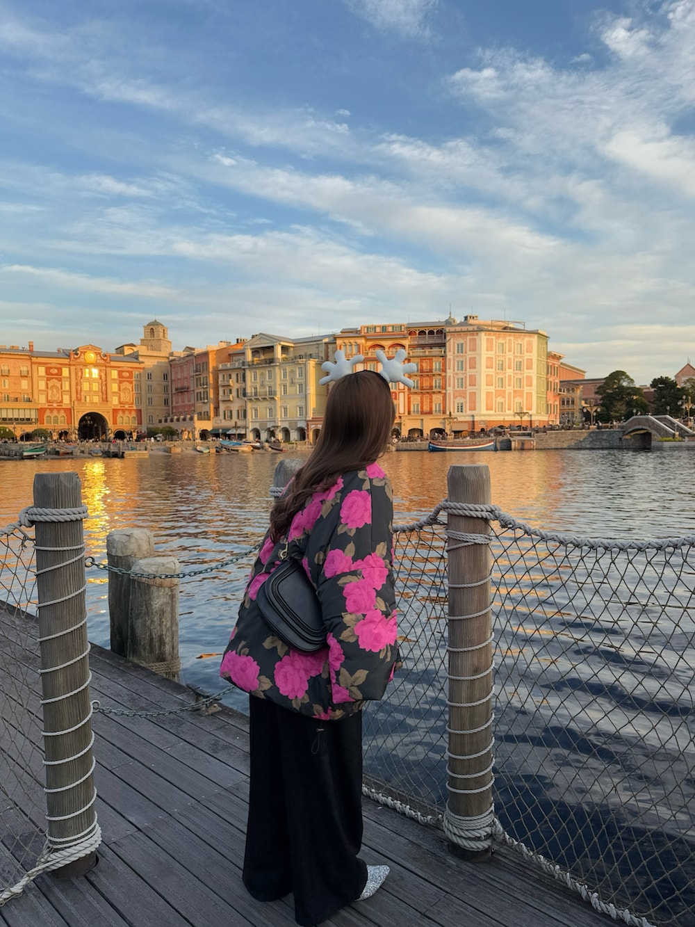 ブラック系のサロペット/オーバーオール、ピンク系のダウンジャケット/コート、シルバー系のローファーを着用したレディースの冬コーディネートの4枚目の写真