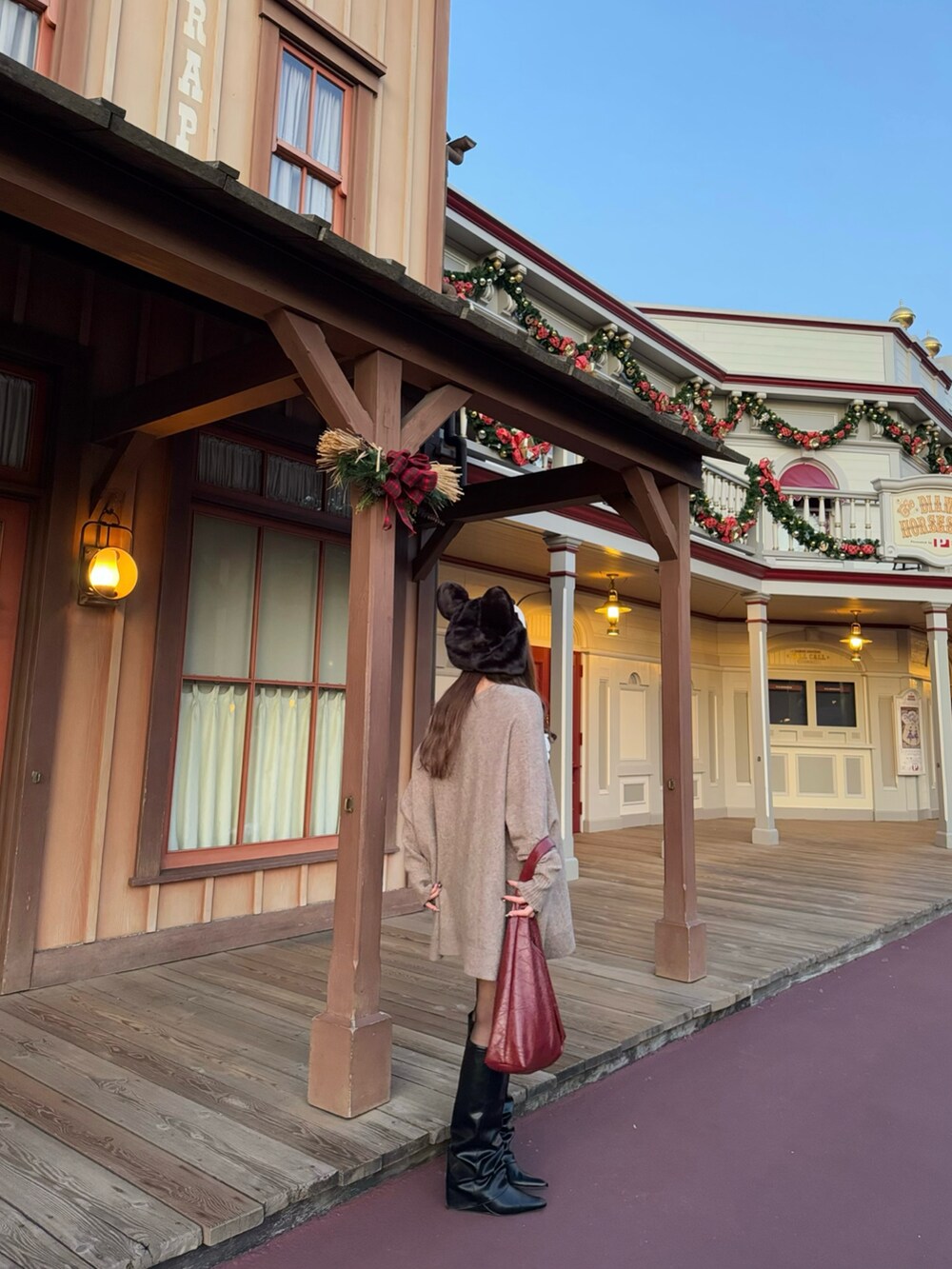 ベージュ系のニット/セーター、レッド系のトートバッグ、ブラック系のブーツを着用したレディースの冬コーディネートの3枚目の写真