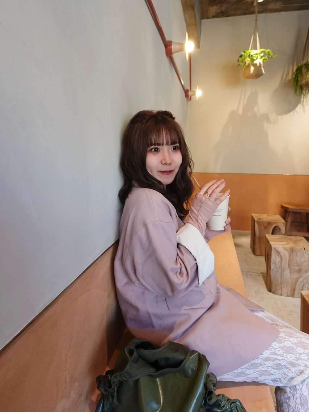 ピンク系のテーラードジャケット、ホワイト系のブーツ、グリーン系のショルダーバッグを着用したレディースの春コーディネートの5枚目の写真