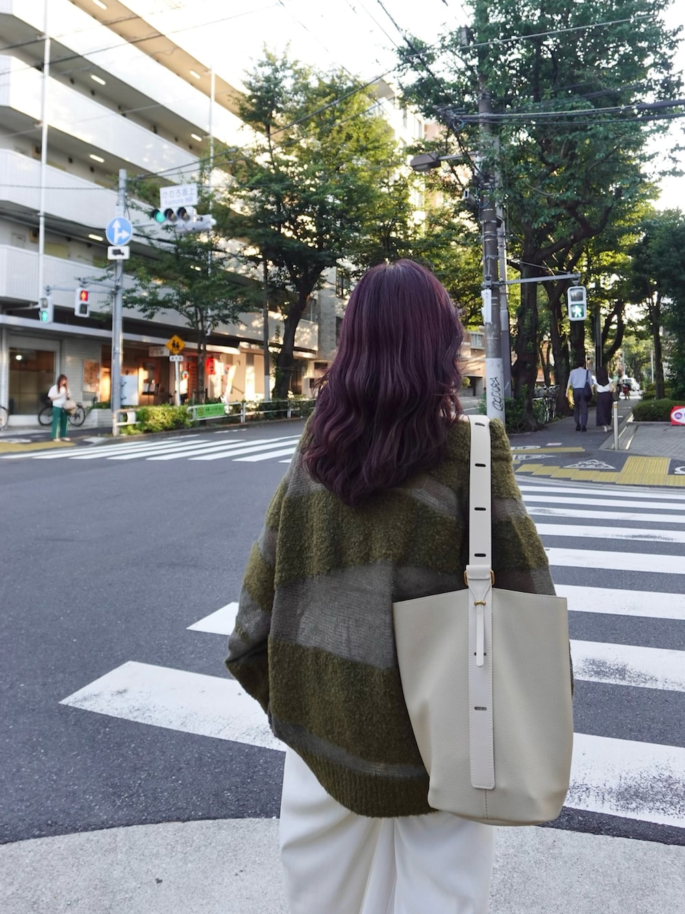 グリーン系のニット/セーター、ホワイト系のスラックス、シルバー系のローファーを着用したレディースの秋コーディネートの3枚目の写真