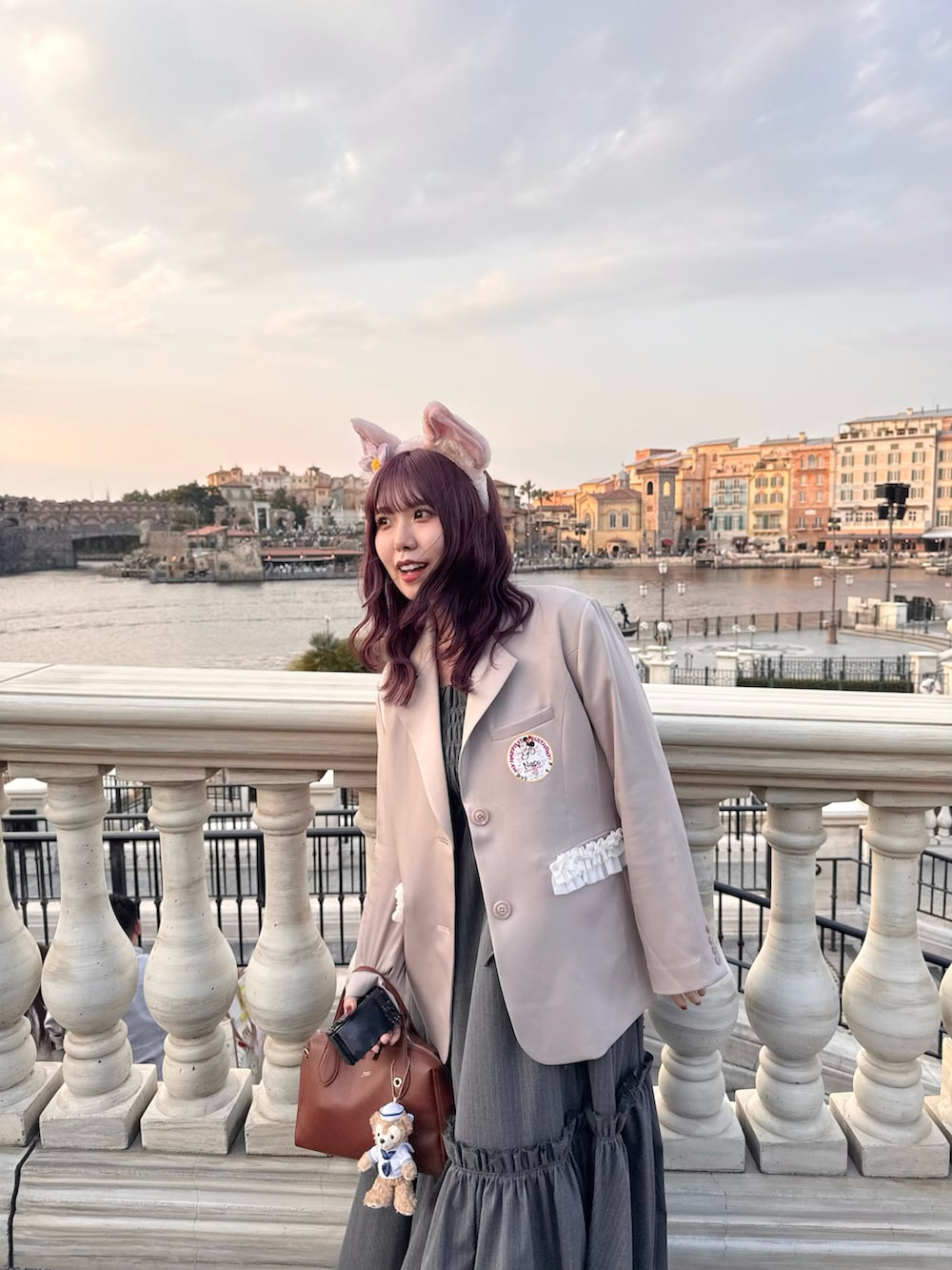 ピンク系のジャケット/アウター、ブラウン系のボストンバッグ、ブラック系のワンピースを着用したレディースの春コーディネートの5枚目の写真