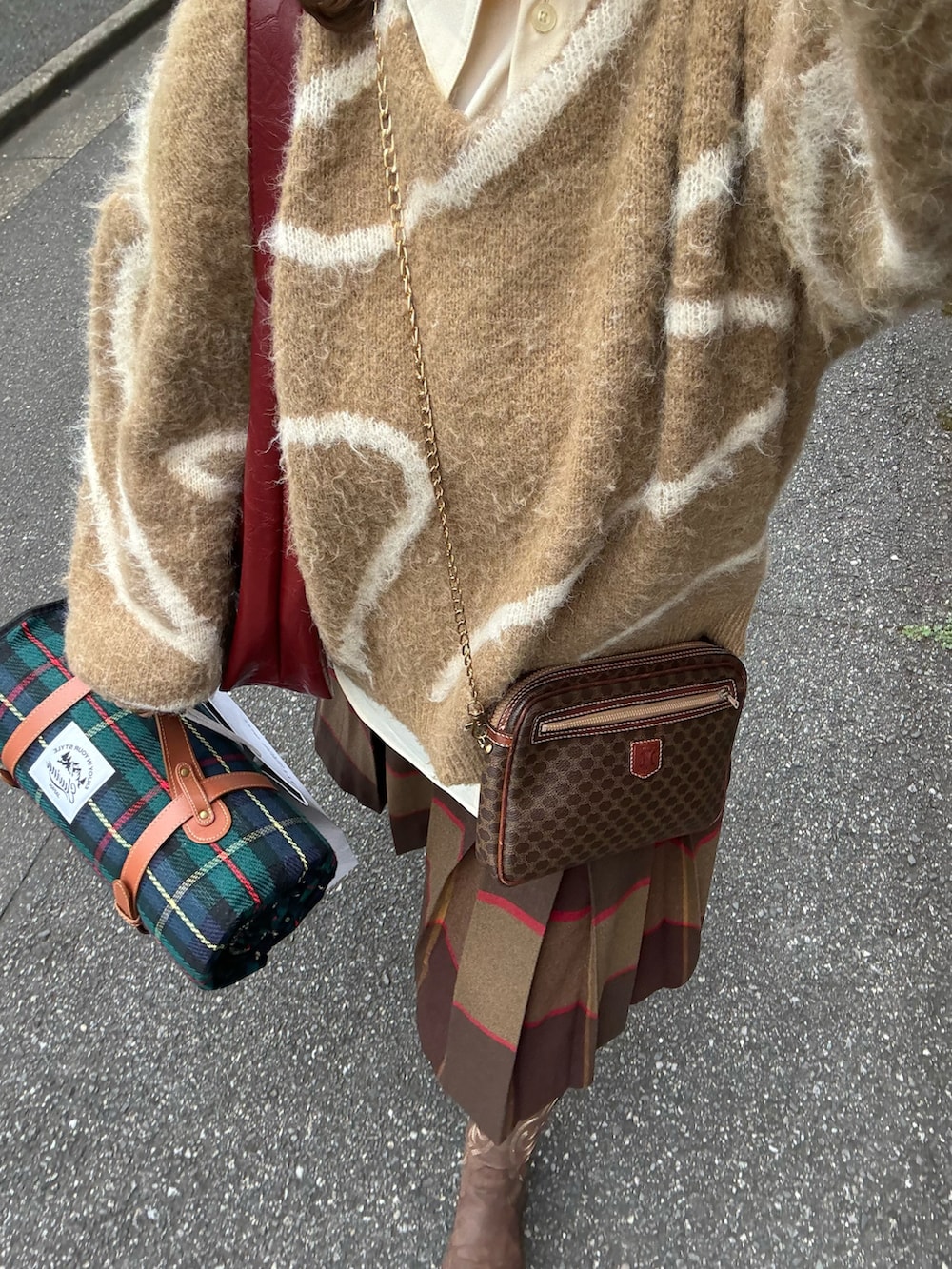 ブラウン系のニット/セーター、ブラウン系のスカート、ベージュ系のシャツ/ブラウスを着用したレディースの秋コーディネートの4枚目の写真