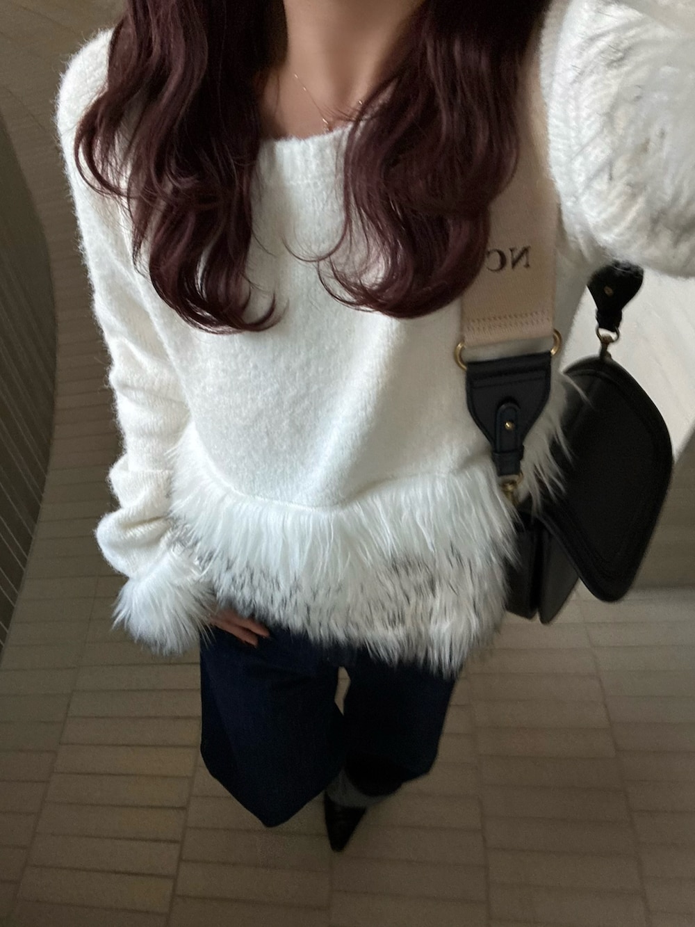 ブルー系のデニムパンツ、ホワイト系のニット/セーターを着用したレディースの冬コーディネートの5枚目の写真