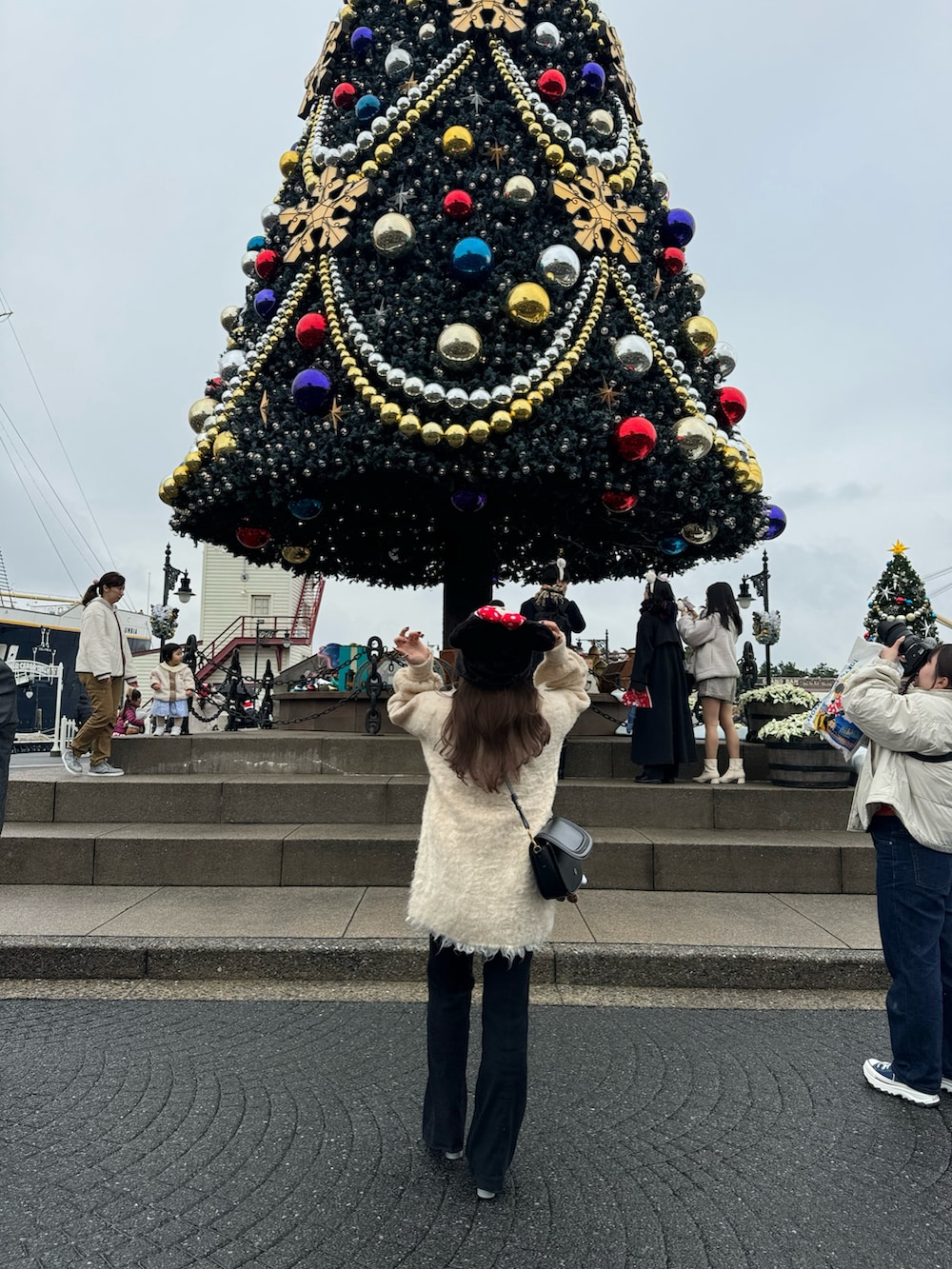 ホワイト系のカーディガン/ボレロ、ブラック系のその他パンツ、シルバー系のブーツを着用したレディースの冬コーディネートの5枚目の写真