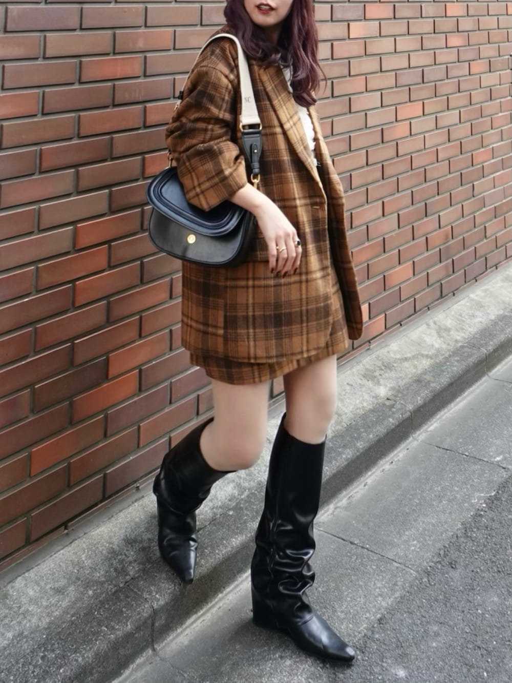 ブラック系のブーツ、ベージュ系のジャケット/アウター、ベージュ系のスカートを着用したレディースの秋コーディネートの2枚目の写真