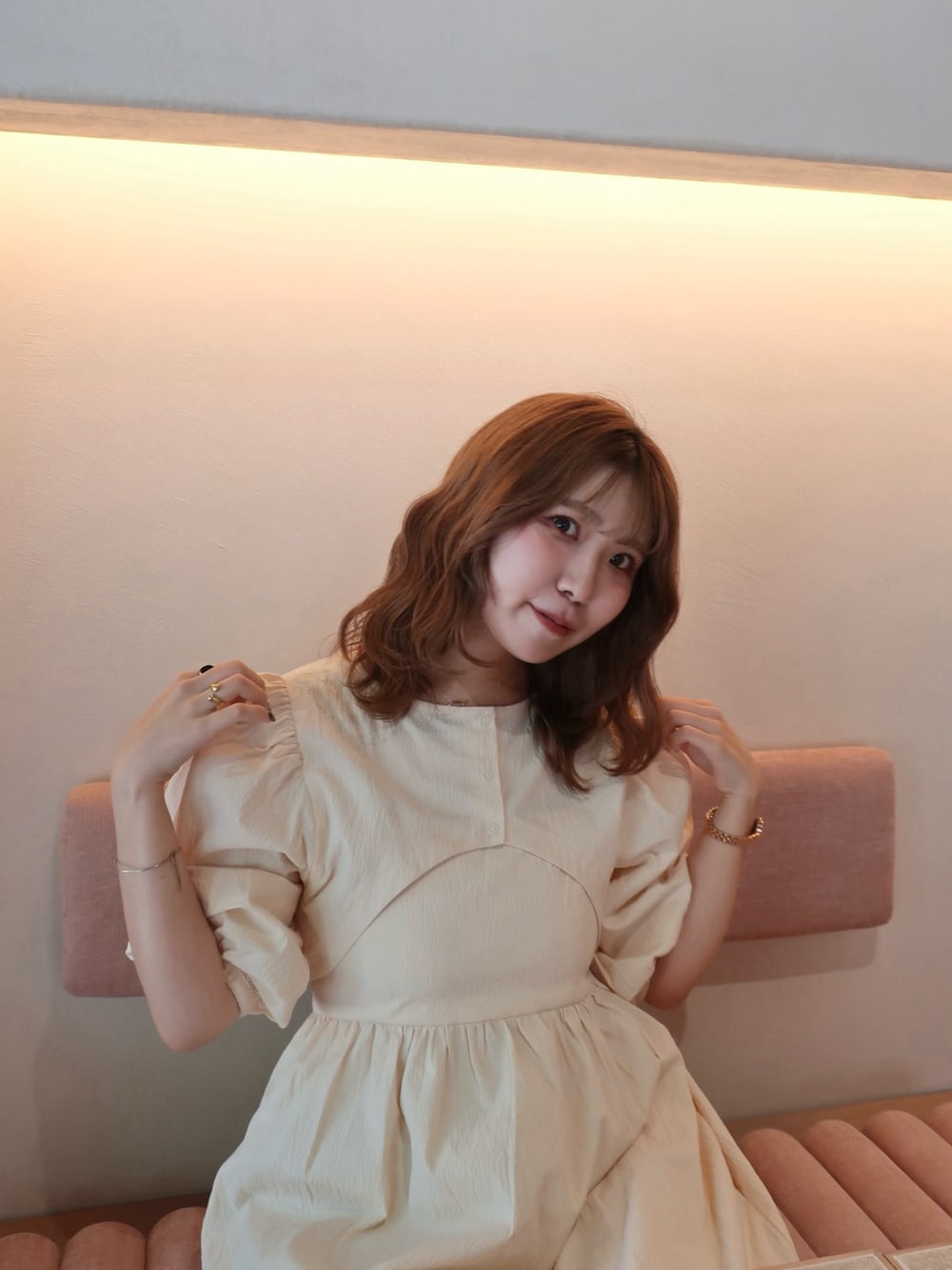 ベージュ系のハンドバッグ、ホワイト系のワンピース、ベージュ系のサンダルを着用したレディースの夏コーディネートの3枚目の写真