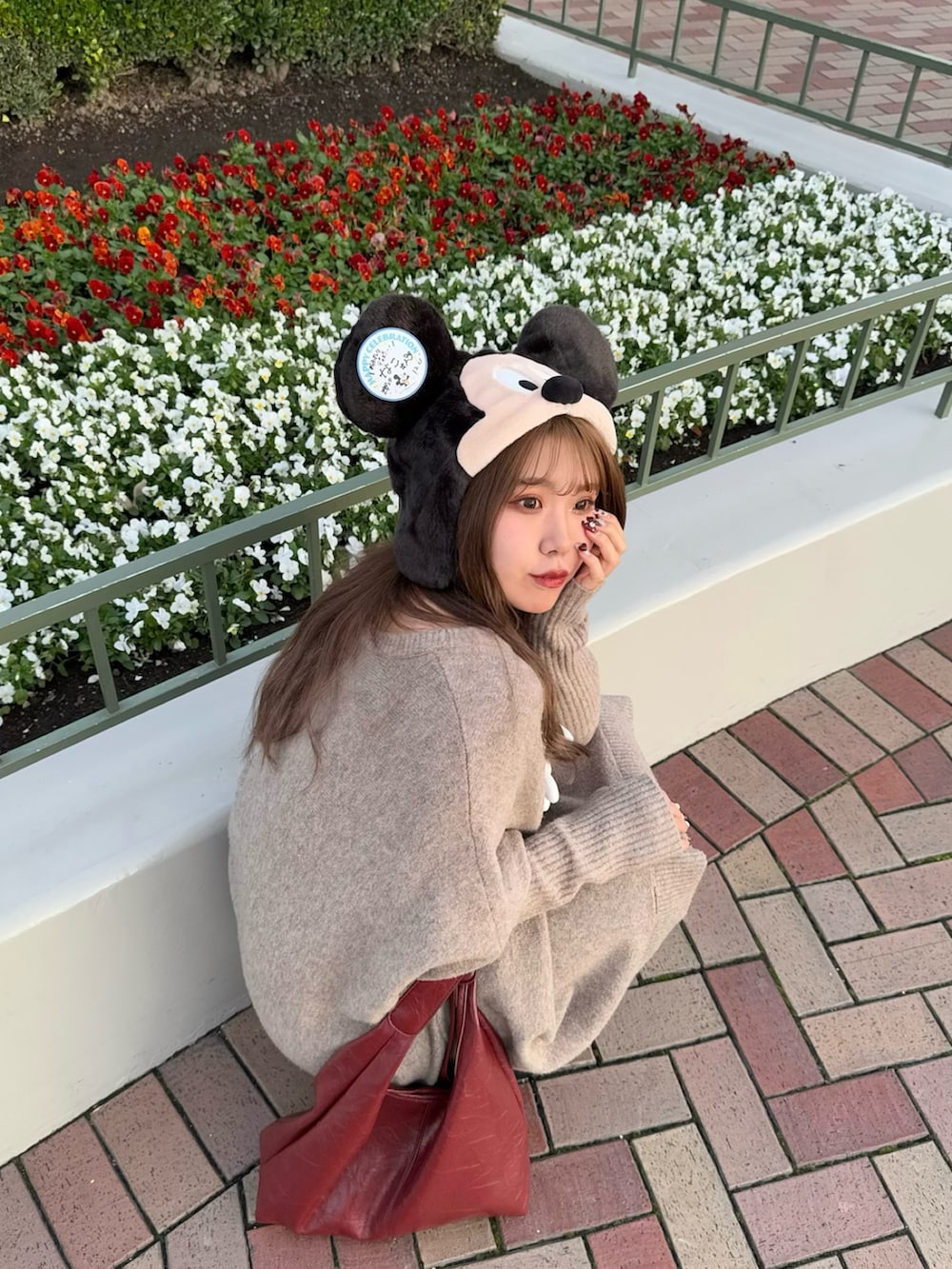 ベージュ系のニット/セーター、レッド系のトートバッグ、ブラック系のブーツを着用したレディースの冬コーディネートの4枚目の写真