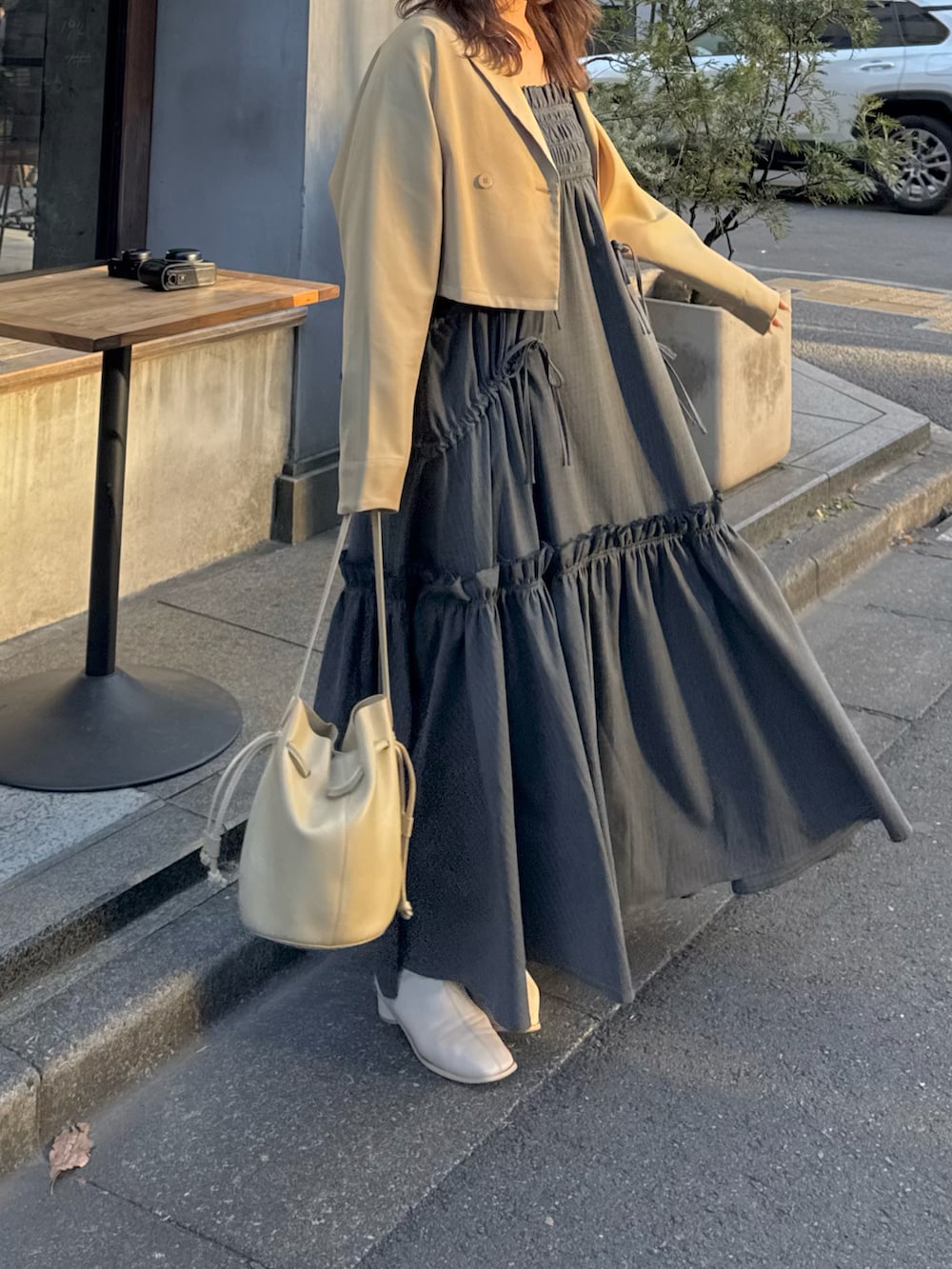 ベージュ系のテーラードジャケット、ブラック系のワンピース、ベージュ系のショルダーバッグを着用したレディースの春コーディネートの2枚目の写真