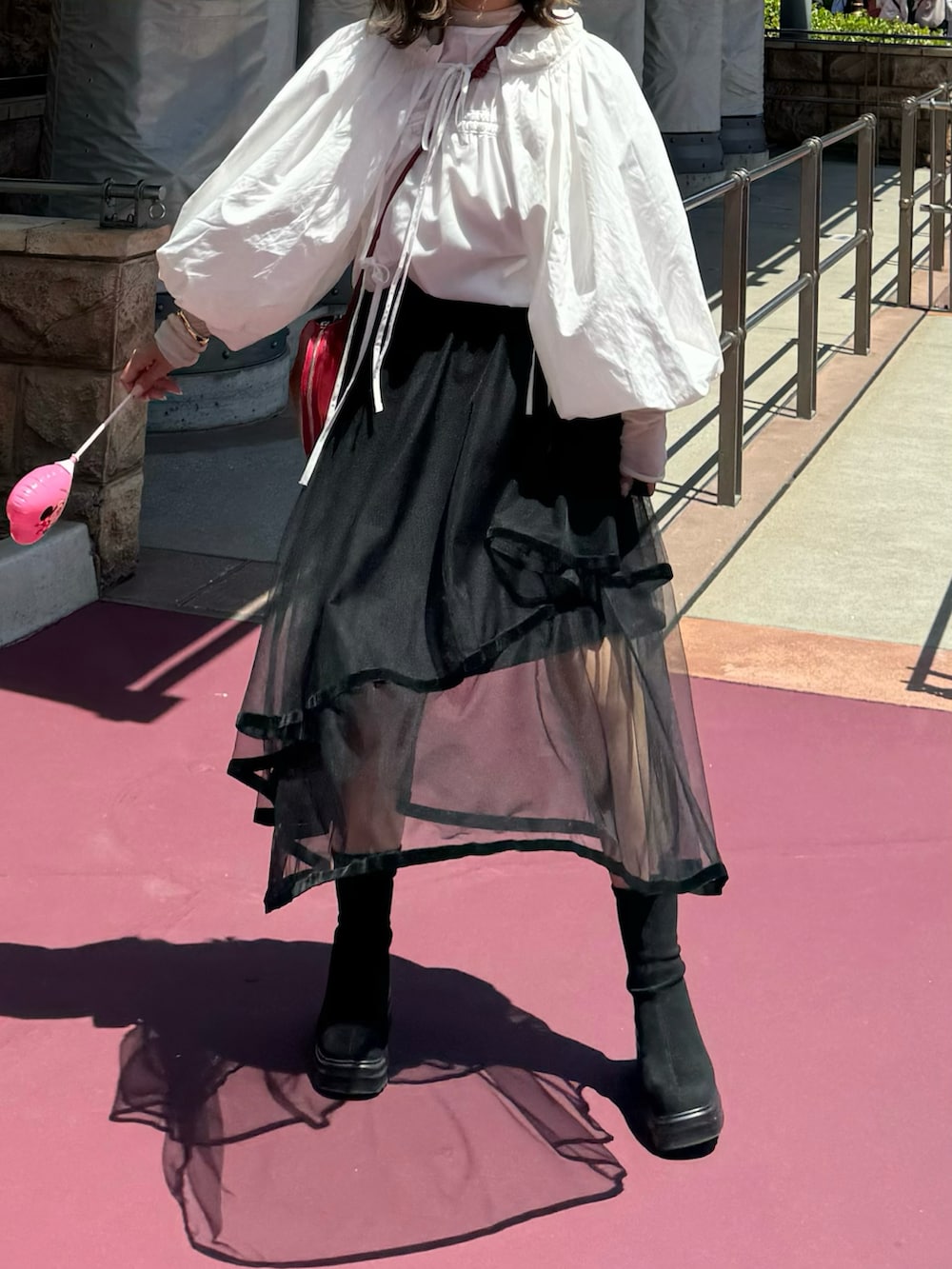 ブラック系のスカート、レッド系のバッグ、ホワイト系のシャツ/ブラウスを着用したレディースの夏コーディネートの2枚目の写真