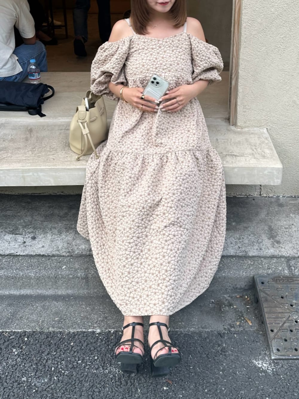 ホワイト系のワンピース、ベージュ系のショルダーバッグ、ブラック系のサンダルを着用したレディースの夏コーディネートの4枚目の写真