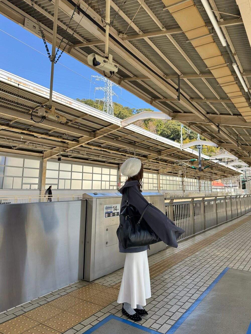 グレー系のスウェット、ホワイト系のスカート、ブラック系のパンプスを着用したレディースの春コーディネートの3枚目の写真