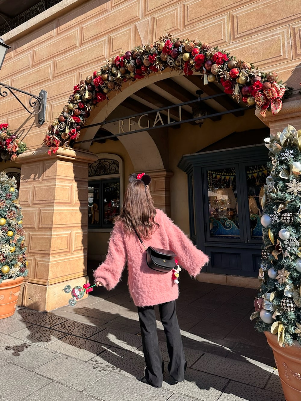 ブラック系のその他パンツ、シルバー系のスニーカー、ピンク系のカーディガン/ボレロを着用したレディースの冬コーディネートの4枚目の写真