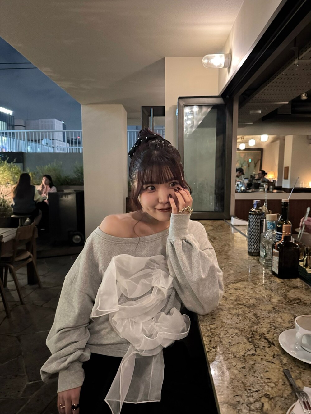 ブラック系のスラックス、グレー系のスウェット、ブラック系のショルダーバッグを着用したレディースの秋コーディネートの2枚目の写真