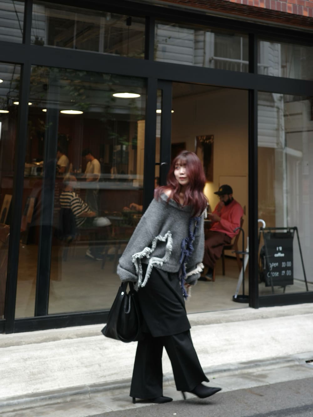 ブラック系のパンツ、ブラック系のショルダーバッグ、グレー系のニット/セーターを着用したレディースの秋コーディネートの4枚目の写真