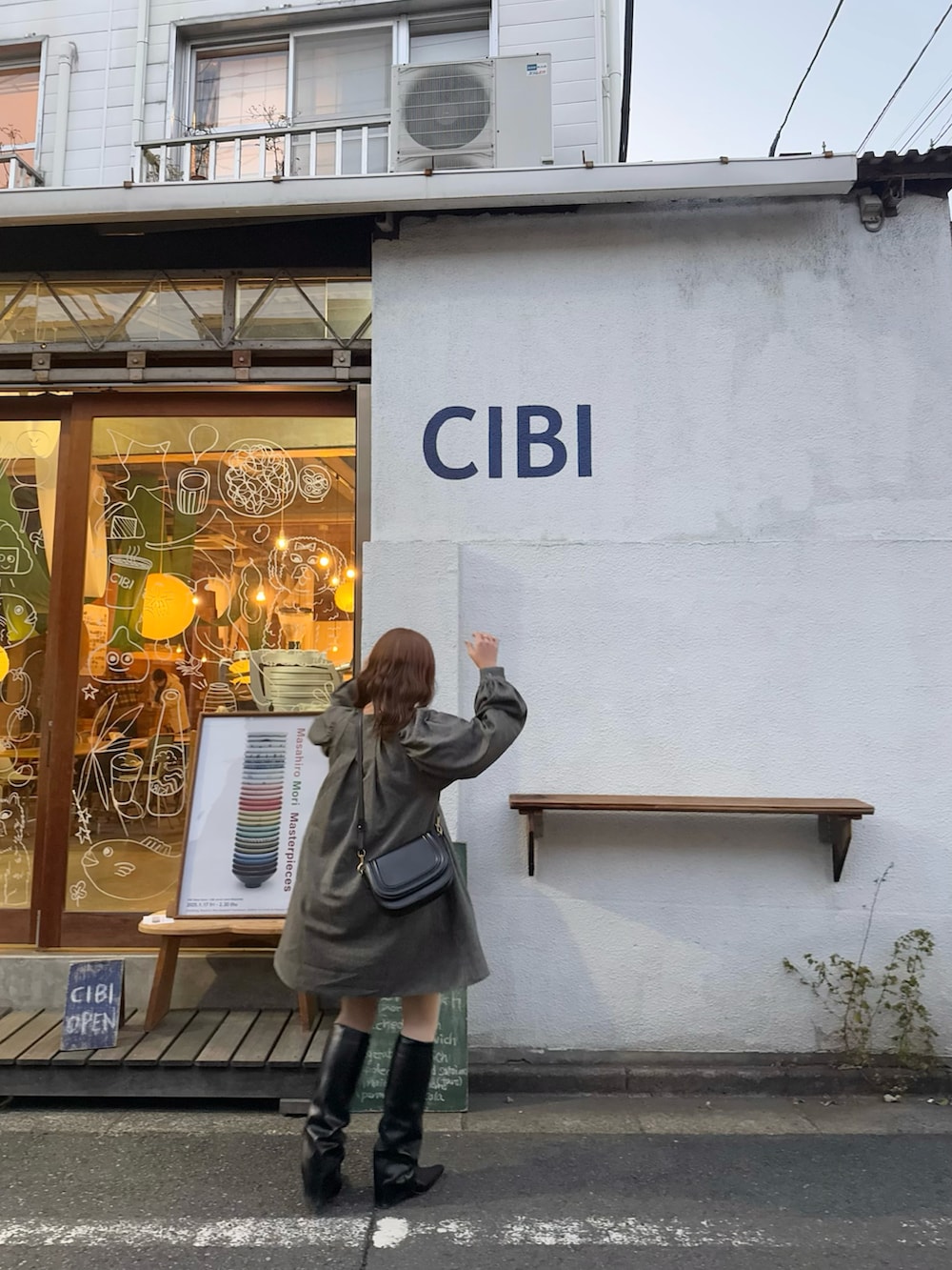 ブラック系のワンピース、ブラック系のブーツを着用したレディースの春コーディネートの5枚目の写真