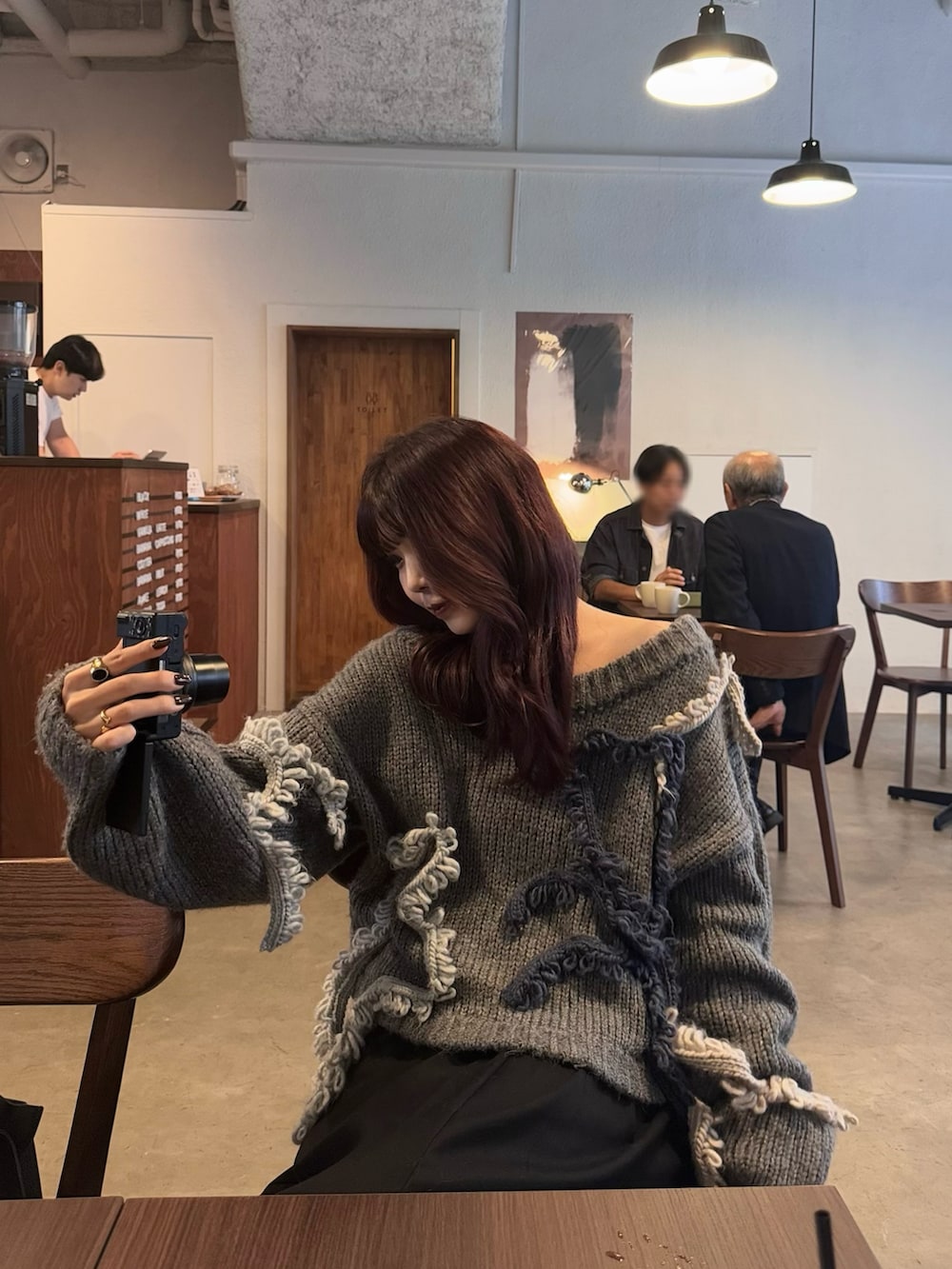 ブラック系のパンツ、ブラック系のショルダーバッグ、グレー系のニット/セーターを着用したレディースの秋コーディネートの5枚目の写真