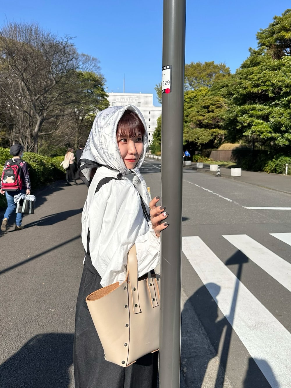 ブラウン系のバレエシューズ、ブラック系のサロペット/オーバーオール、ホワイト系のシャツ/ブラウスを着用したレディースの春コーディネートの2枚目の写真