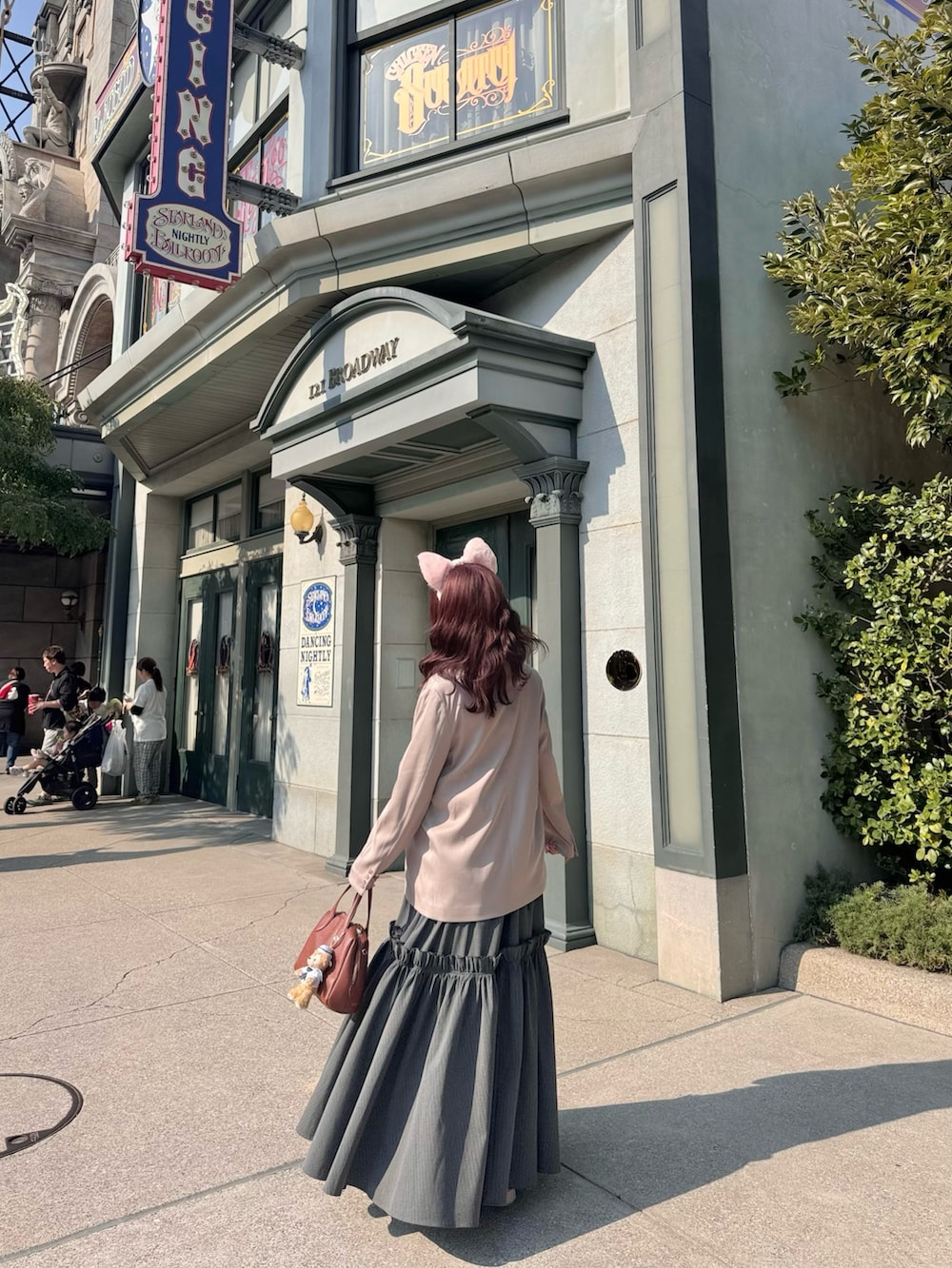 ピンク系のジャケット/アウター、ブラウン系のボストンバッグ、ブラック系のワンピースを着用したレディースの春コーディネートの3枚目の写真