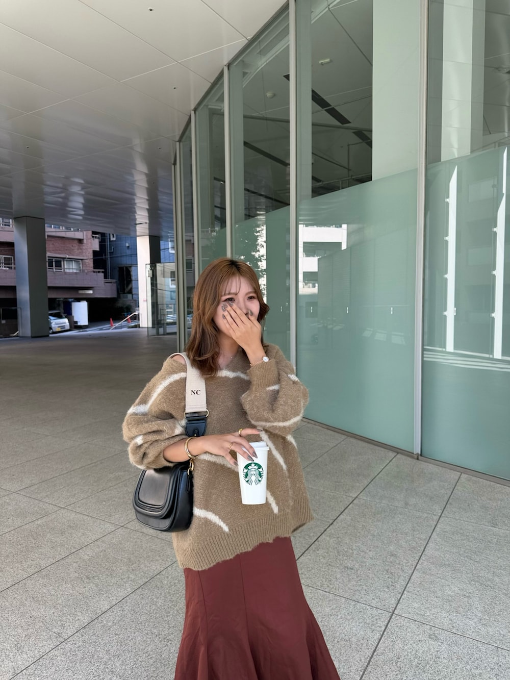 ブラウン系のスカート、ホワイト系のブーツ、ブラウン系のニット/セーターを着用したレディースの秋コーディネートの5枚目の写真