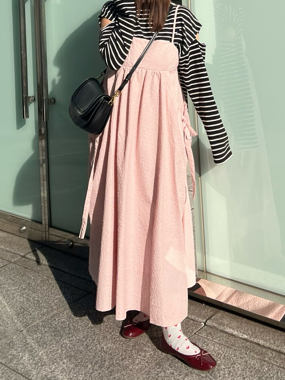 ブラック系のTシャツ/カットソー、ピンク系のワンピース、レッド系のバレエシューズを着用したレディースの冬コーディネートの2枚目の写真