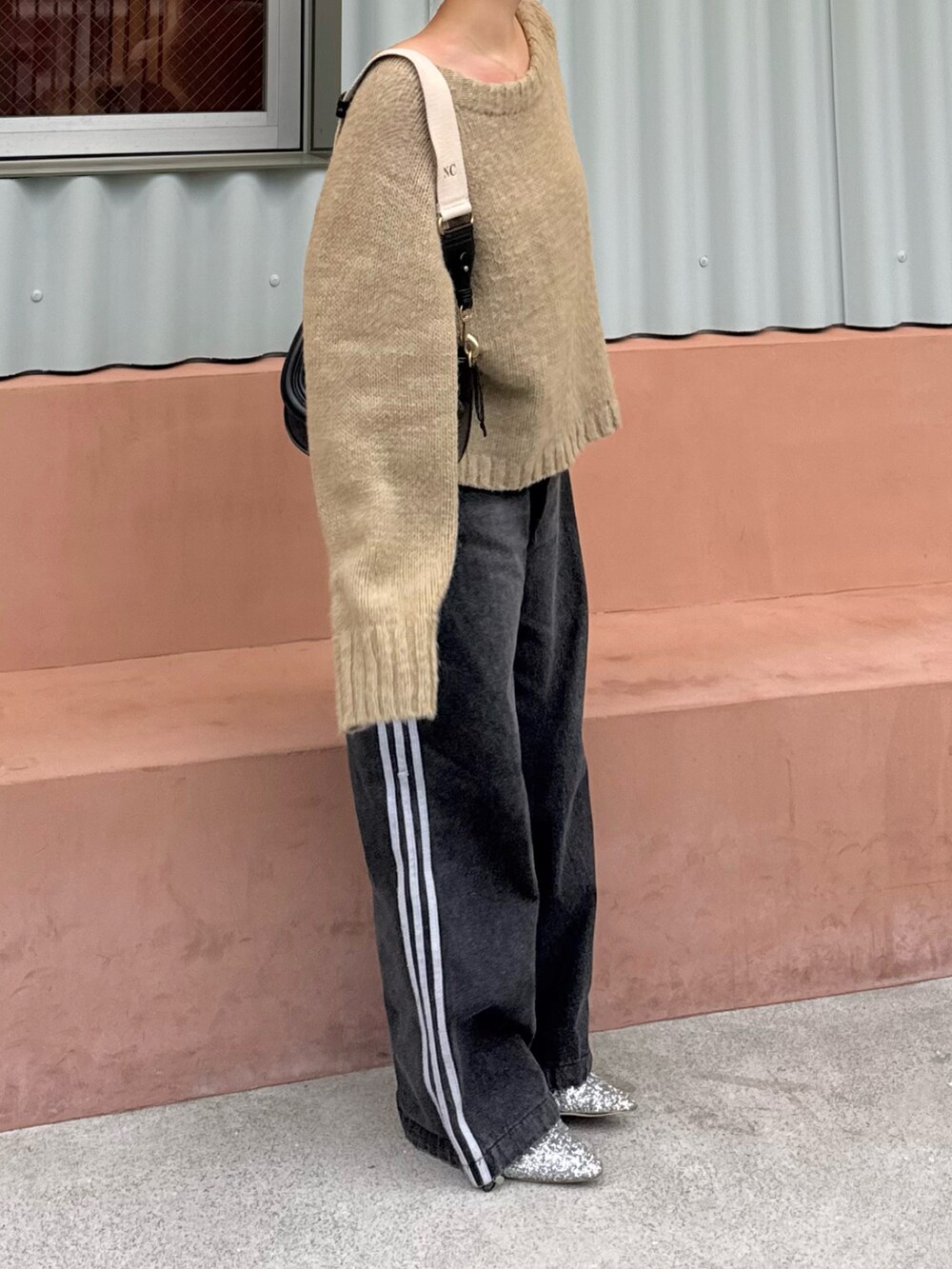 ベージュ系のニット/セーター、ブラック系のデニムパンツ、シルバー系のローファーを着用したレディースの春コーディネートの2枚目の写真