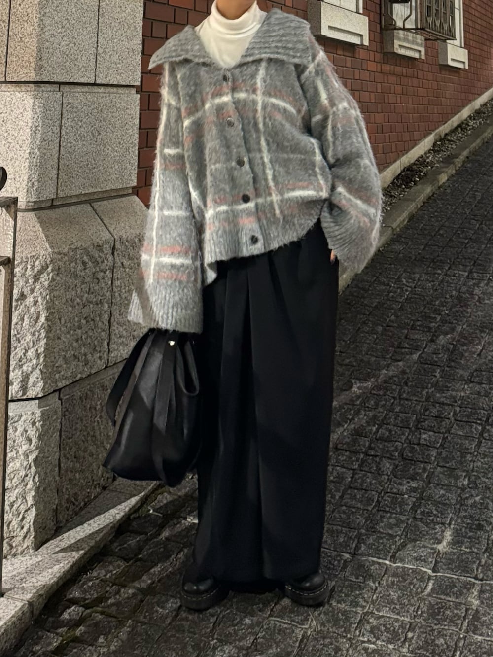 グレー系のニット/セーター、ブラック系のスラックスを着用したレディースの冬コーディネートの5枚目の写真