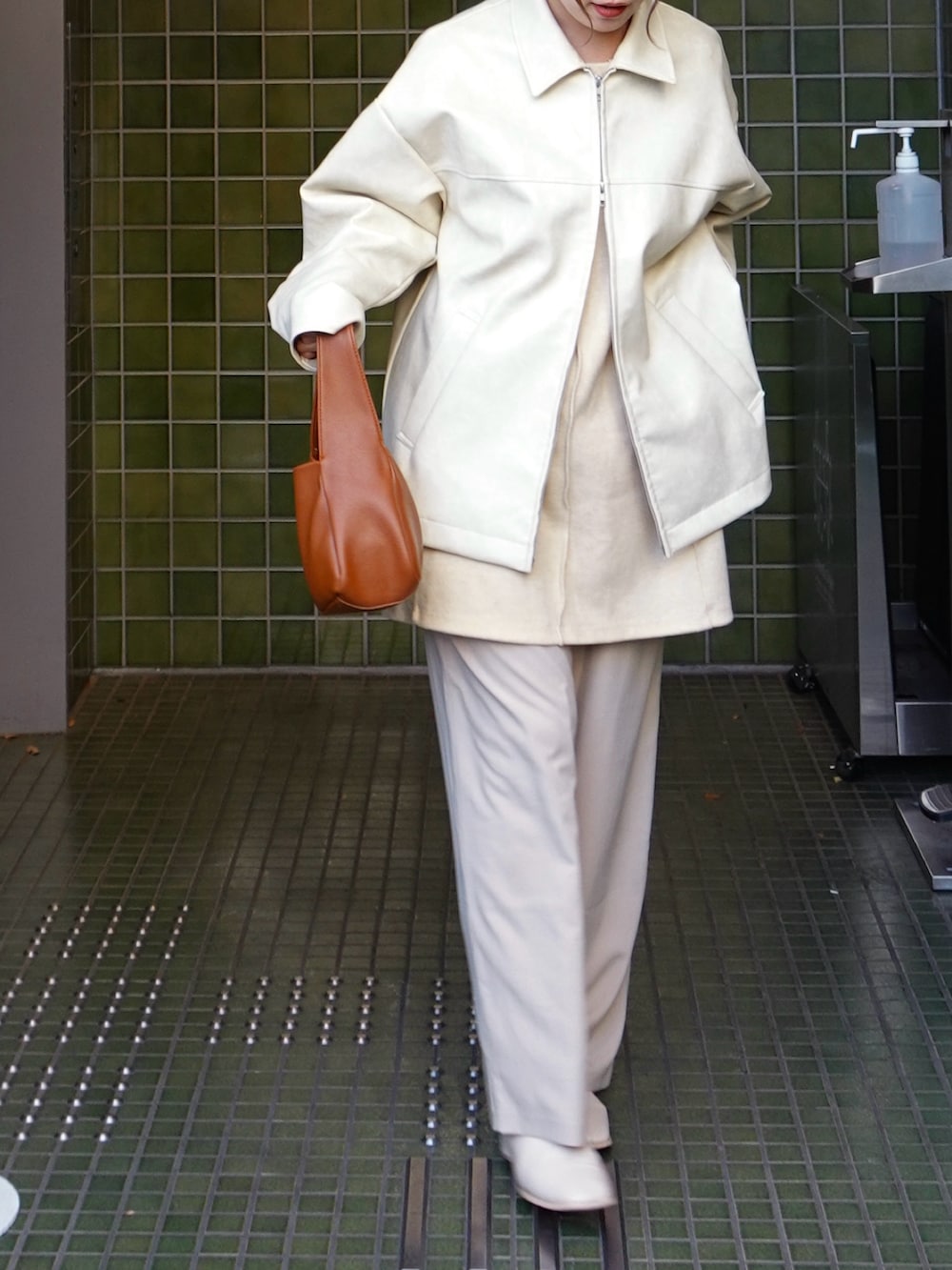 ホワイト系のブルゾン、ホワイト系のスラックス、ホワイト系のカーディガン/ボレロを着用したレディースの春コーディネートの5枚目の写真