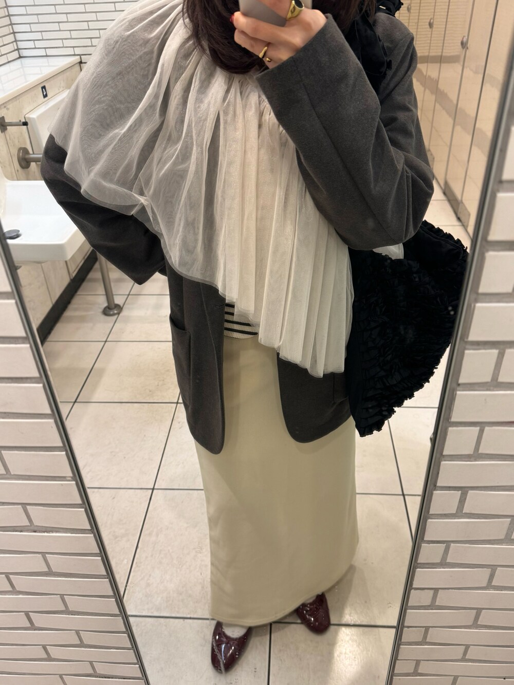 ホワイト系のチューブトップ、ブラック系のトートバッグ、ホワイト系のスカートを着用したレディースの春コーディネートの5枚目の写真