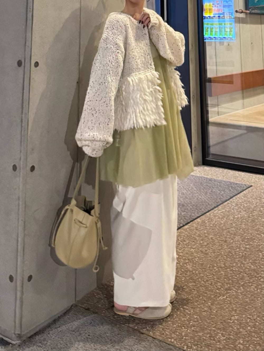 ベージュ系のショルダーバッグ、ベージュ系のサンダル、ホワイト系のスラックスを着用したレディースの秋コーディネートの2枚目の写真