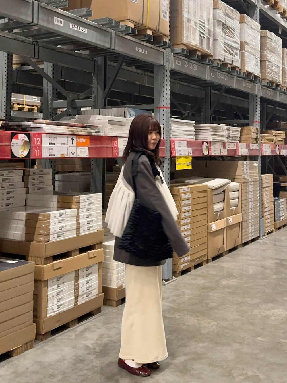 ホワイト系のチューブトップ、ブラック系のトートバッグ、ホワイト系のスカートを着用したレディースの春コーディネートの4枚目の写真