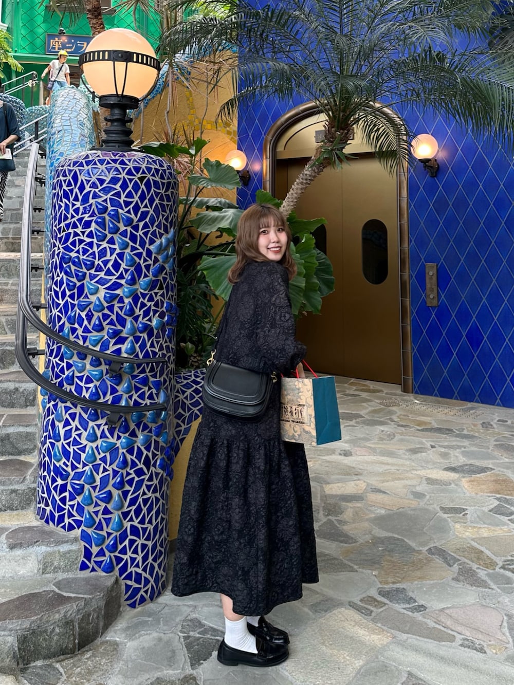 ブラック系のショルダーバッグ、ブラック系のワンピースを着用したレディースの夏コーディネートの3枚目の写真