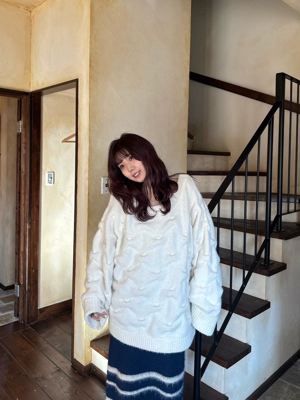 ホワイト系のニット/セーター、ブルー系のスカートを着用したレディースの冬コーディネートの4枚目の写真