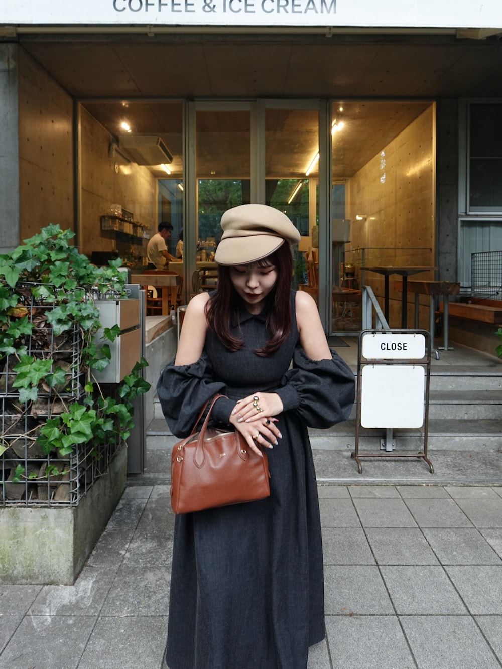 ブラウン系のボストンバッグ、ブラック系のローファー、ブラック系のワンピース/ドレスを着用したレディースの秋コーディネートの3枚目の写真