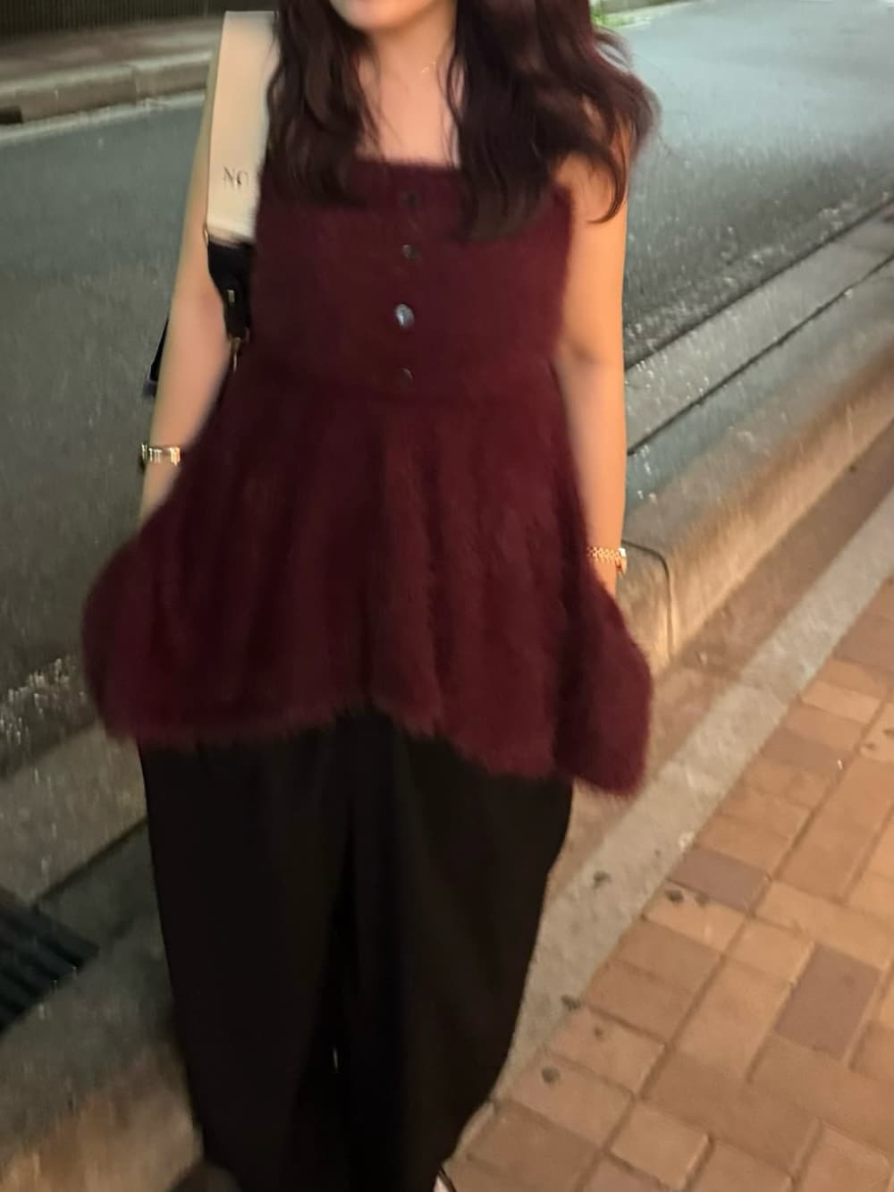 ブラック系のスラックス、レッド系のニット/セーターを着用したレディースの夏コーディネートの3枚目の写真