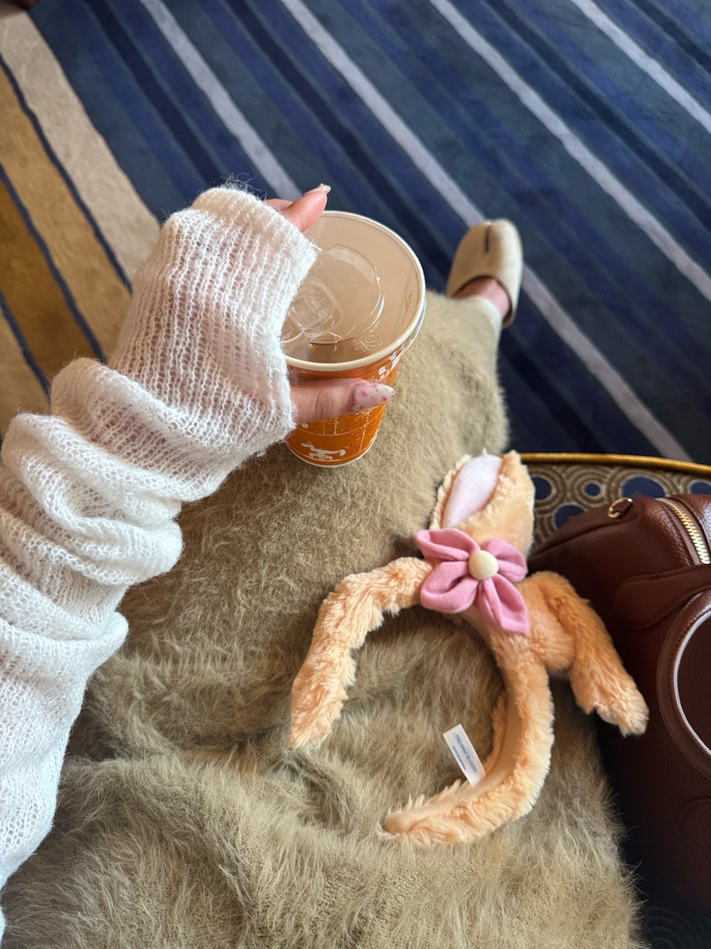 ブラウン系のボストンバッグ、ベージュ系のサンダル、ベージュ系のトップスを着用したレディースの秋コーディネートの4枚目の写真