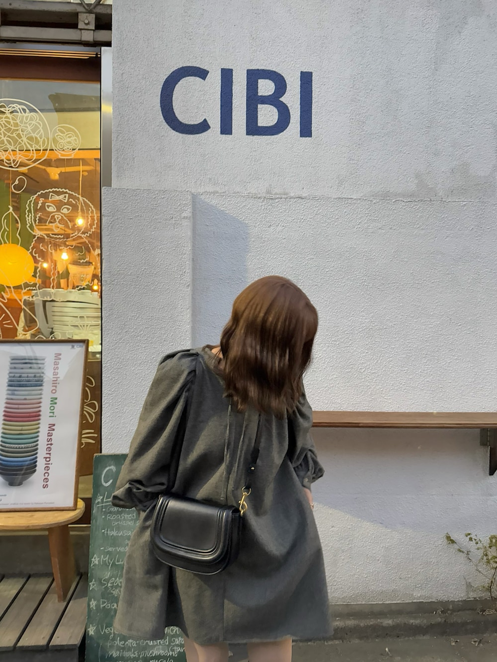 ブラック系のワンピース、ブラック系のブーツを着用したレディースの春コーディネートの3枚目の写真