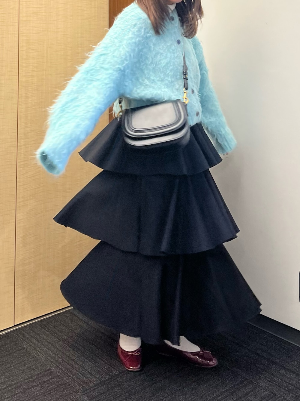 レッド系のバレエシューズ、ブラック系のショルダーバッグ、ブルー系のカーディガン/ボレロを着用したレディースの冬コーディネートの2枚目の写真