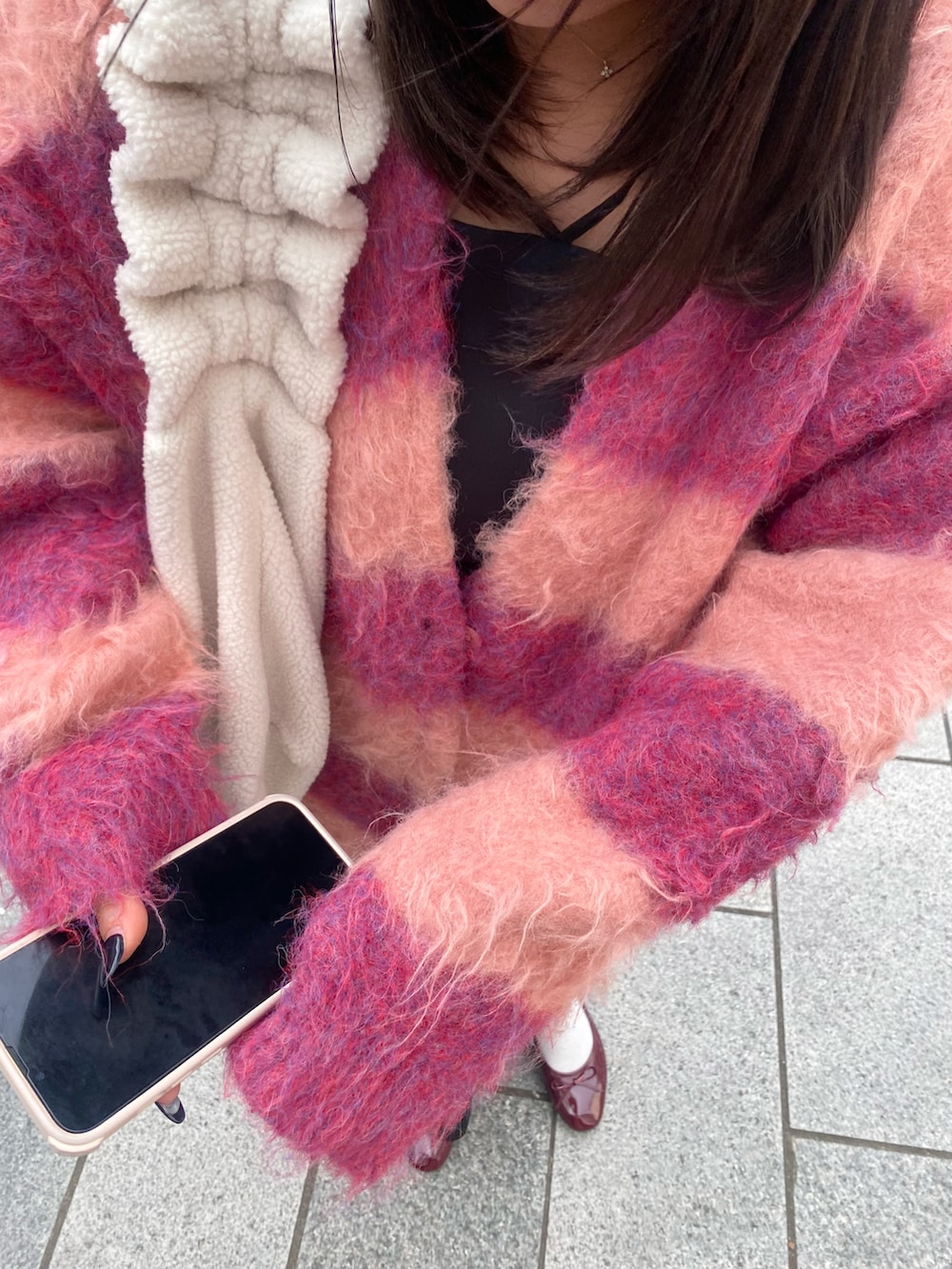 レッド系のカーディガン/ボレロ、ブラック系のワンピース/ドレス、レッド系のバレエシューズを着用したレディースの冬コーディネートの5枚目の写真